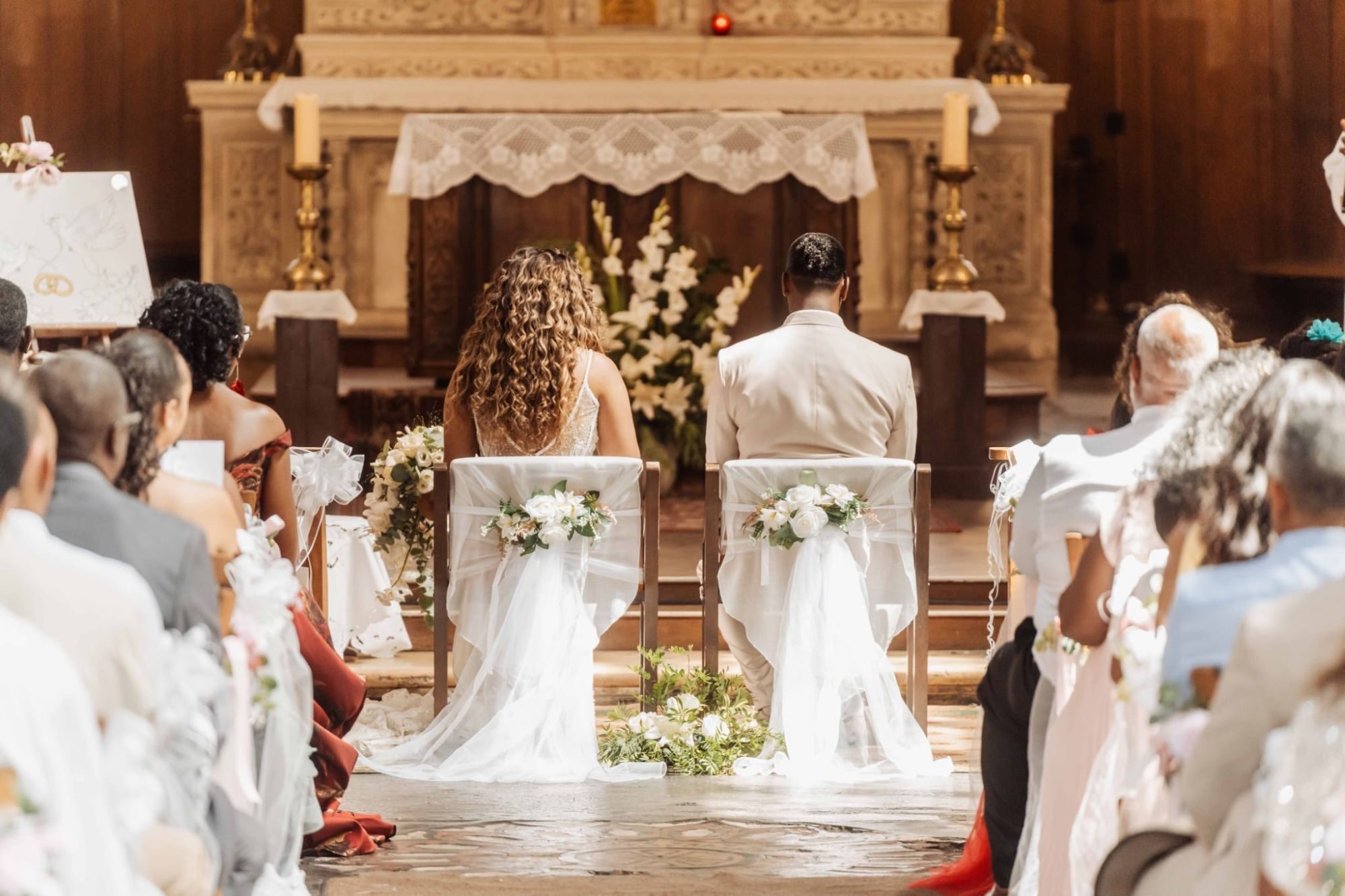 Des maries de dos pendant leur ceremonie a l'eglise