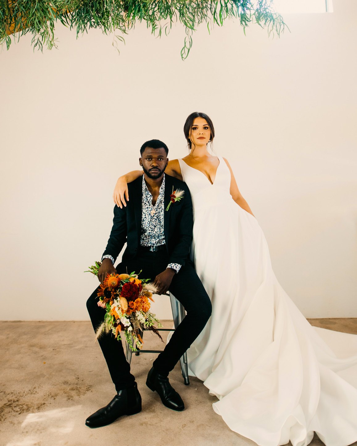 Un couple de mariés assis sous la verdure